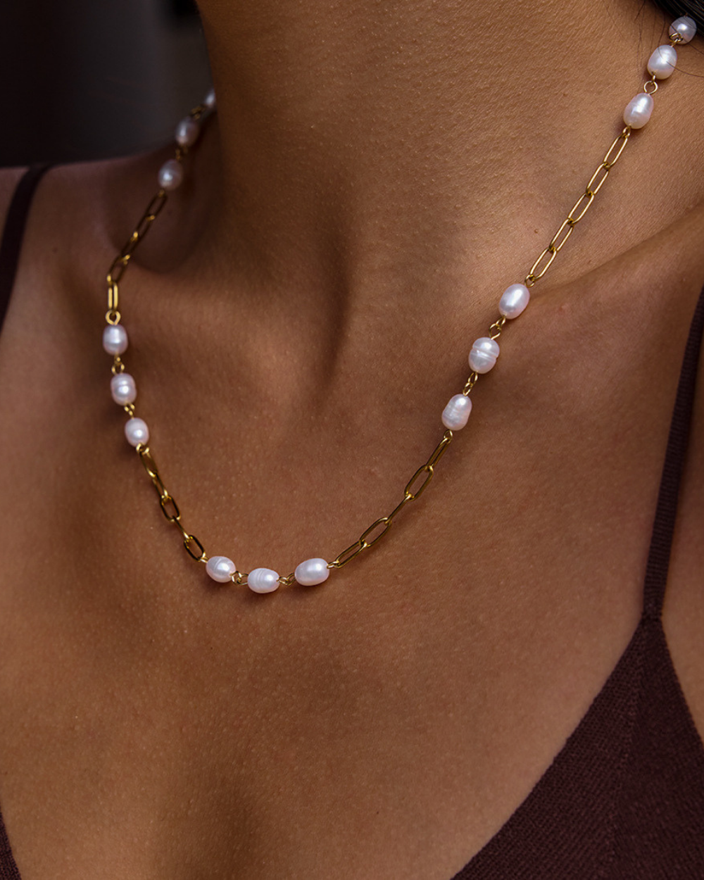 Pearl necklace with gold chain on a person's neck