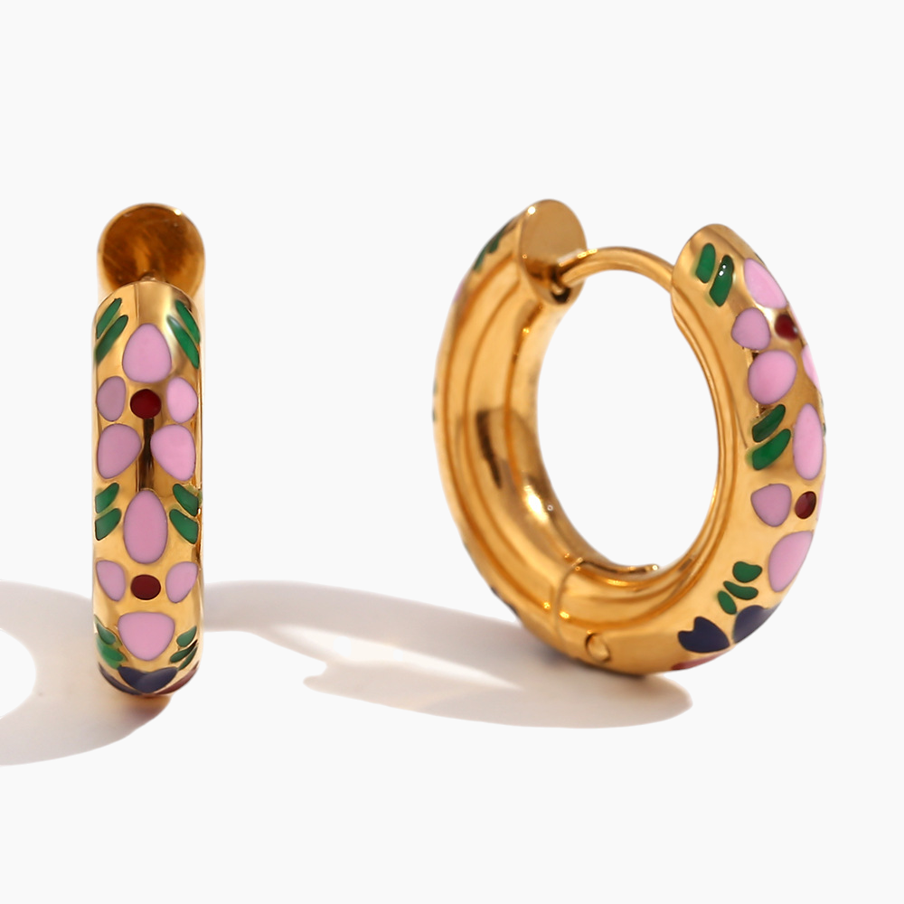 Gold hoop earrings with floral design on a white background