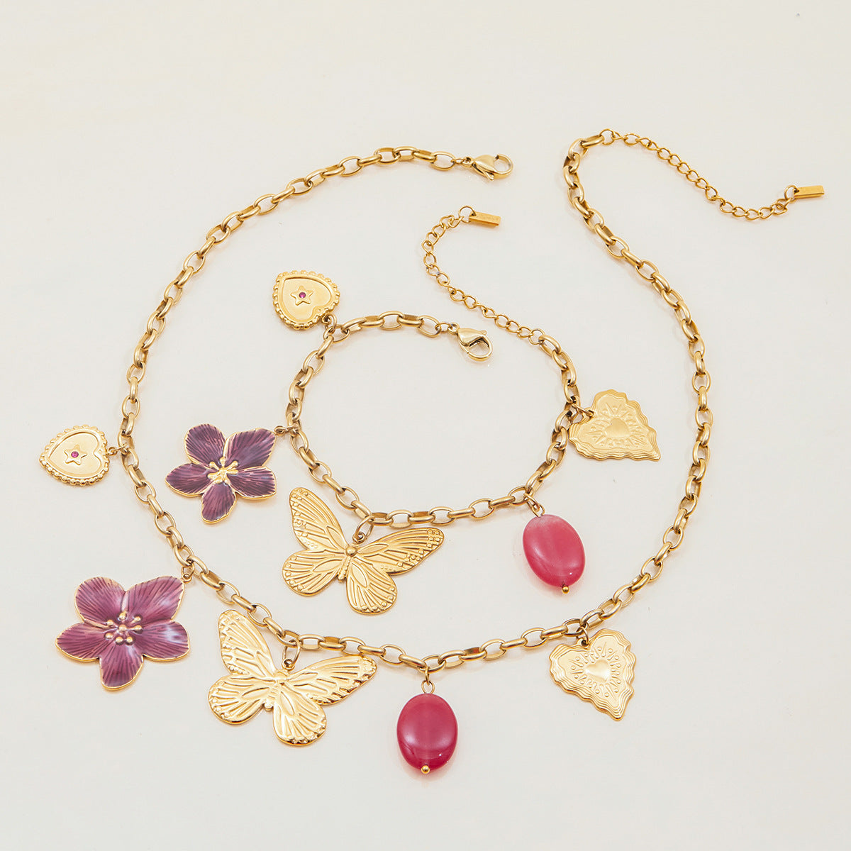 Pink and gold charm necklace flatlay with feminine beach vibe