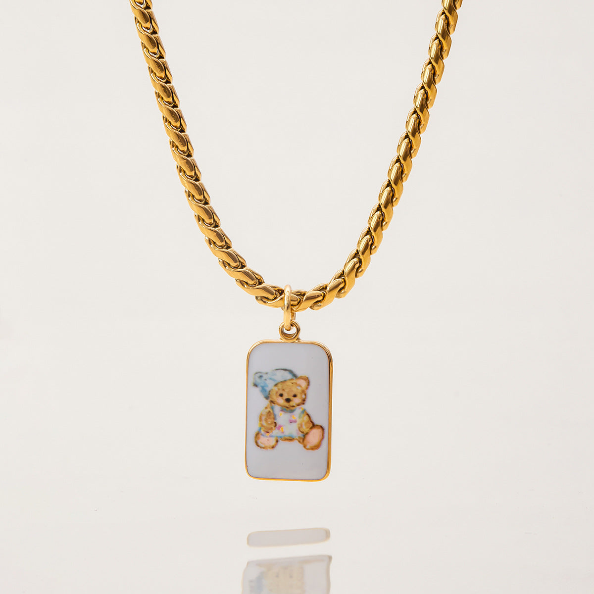 Full view of teddy bear pendant necklace on gold curb chain with lobster clasp