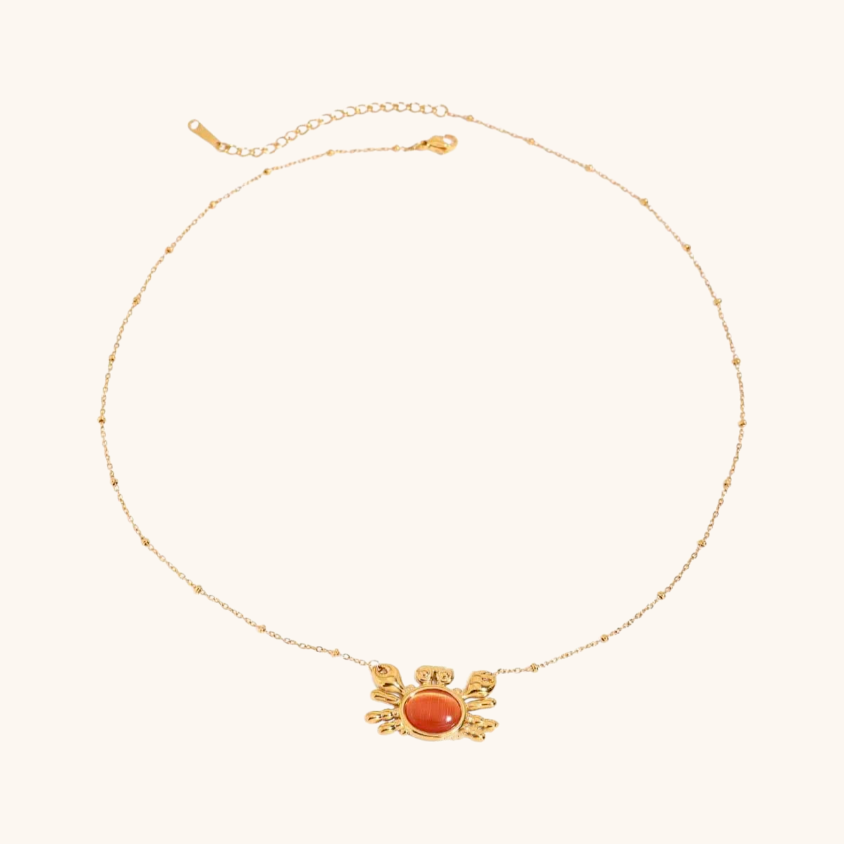 Flat lay of crab-shaped necklace and ring with seashells and citrus