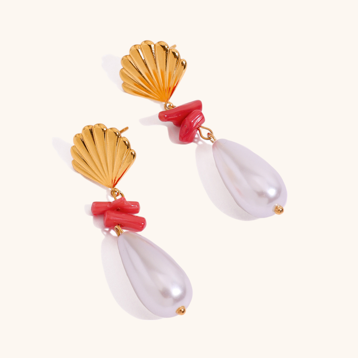 Gold seashell earrings with red coral and white pearl drop, ocean-inspired design