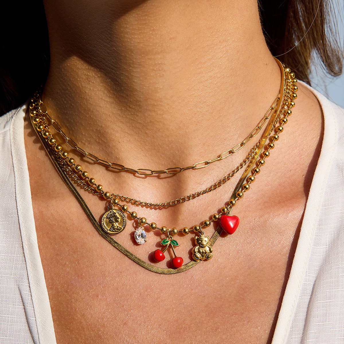 Gold necklace with cherry, heart, and bear pendants for women
