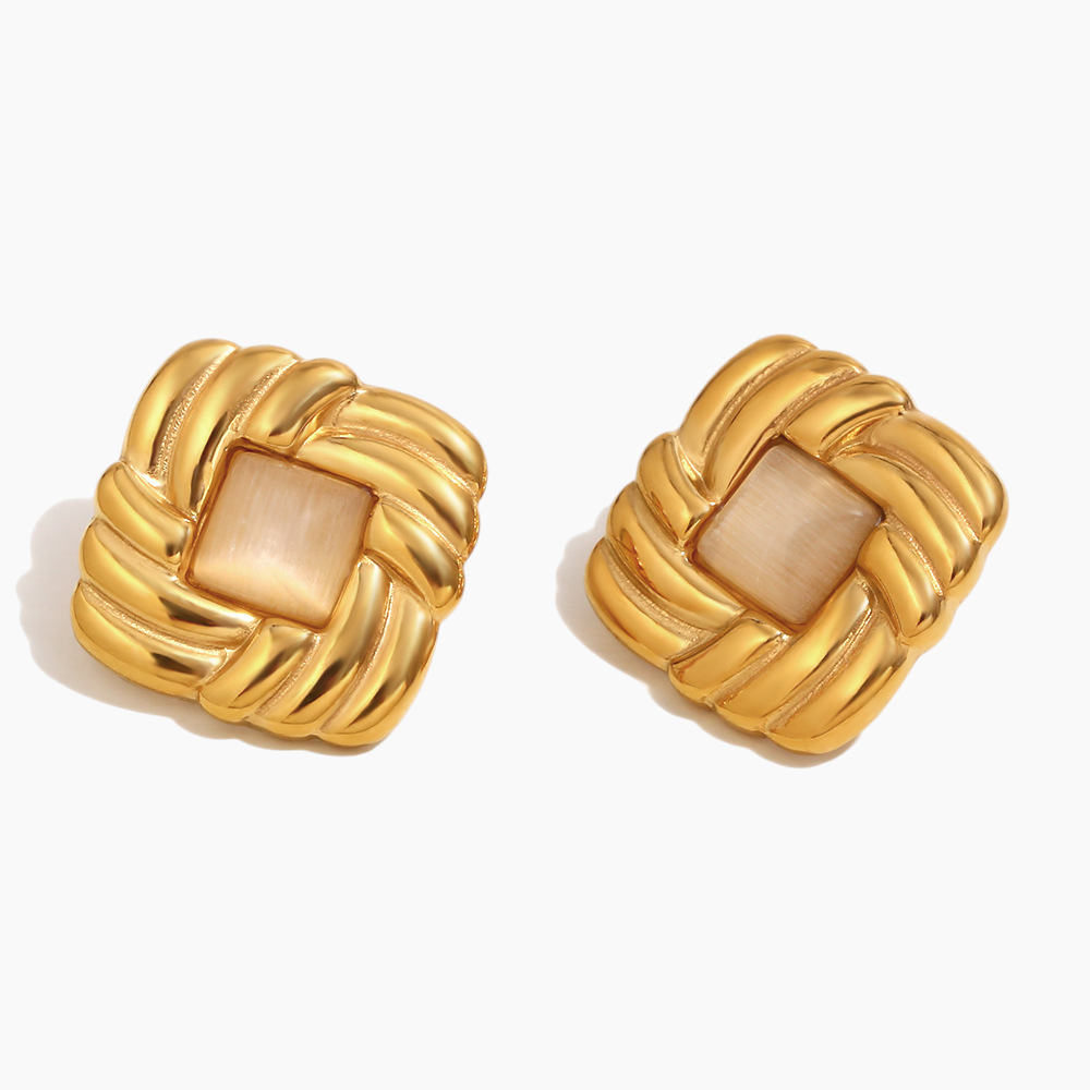 Pair of gold earrings with a beige center on a white background