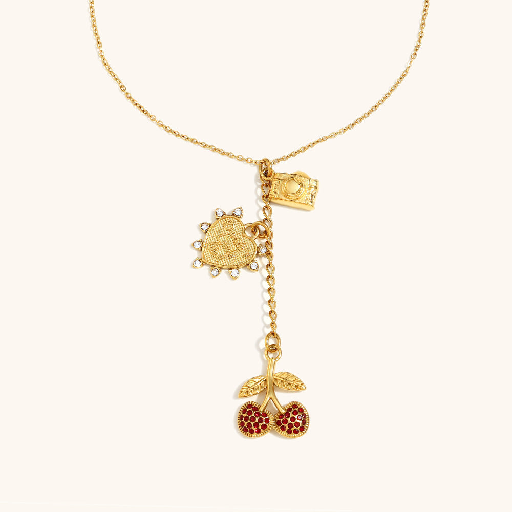 gold necklace with red cherry pendant, camera and heart charms