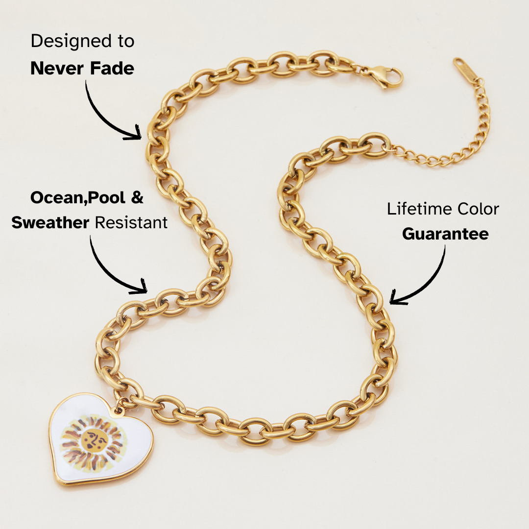Close-up of gold heart pendant featuring artistic sun face design