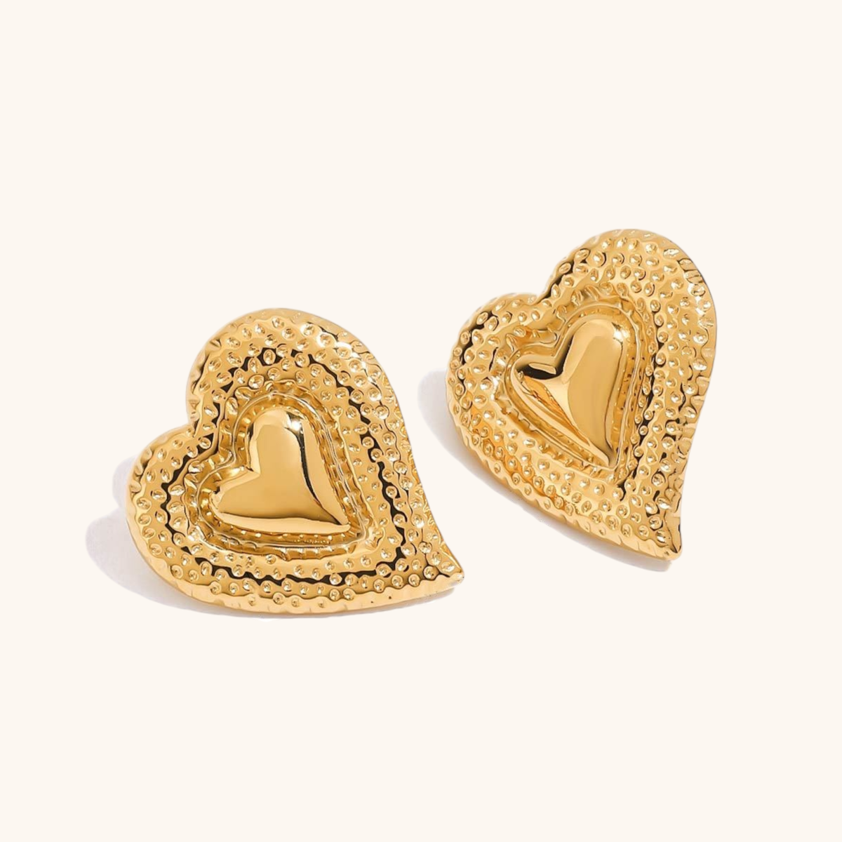 Close-up of retro heart-shaped gold earrings with hammered texture