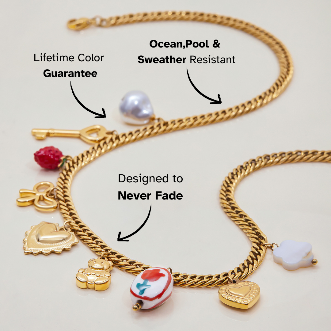 Flat lay of gold necklace with pearl, strawberry, bow, and key charms