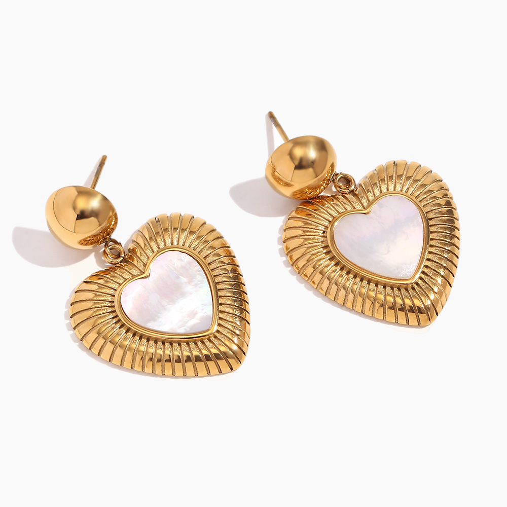 Gold heart-shaped earrings with white centers on a white background