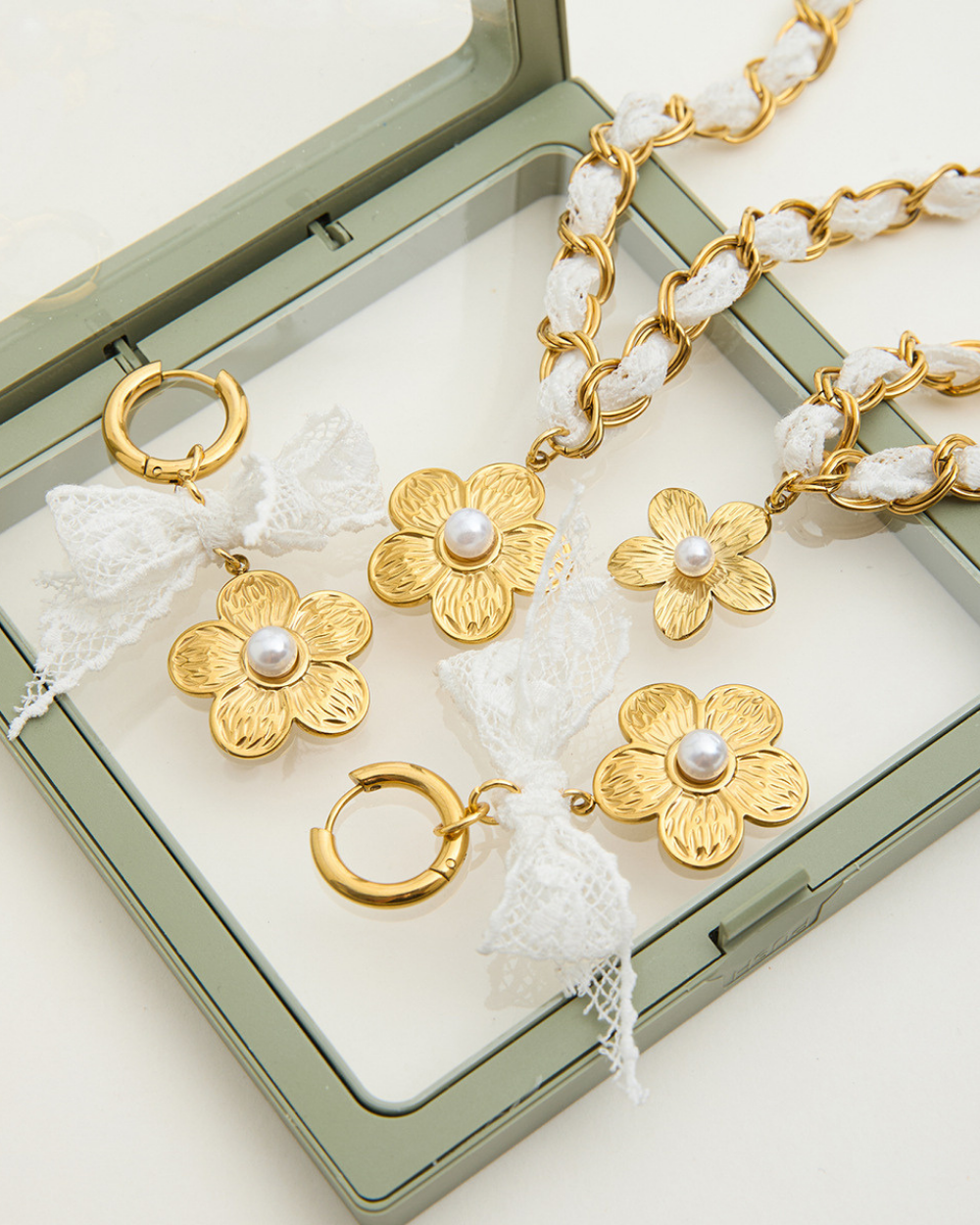 Gold floral jewelry set with pearls on a green jewelry box