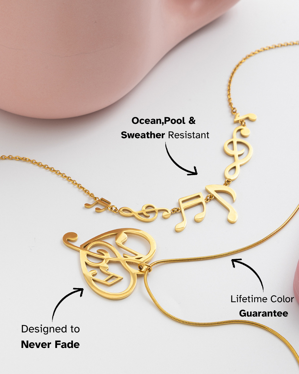 Gold necklace with musical note designs on a white background