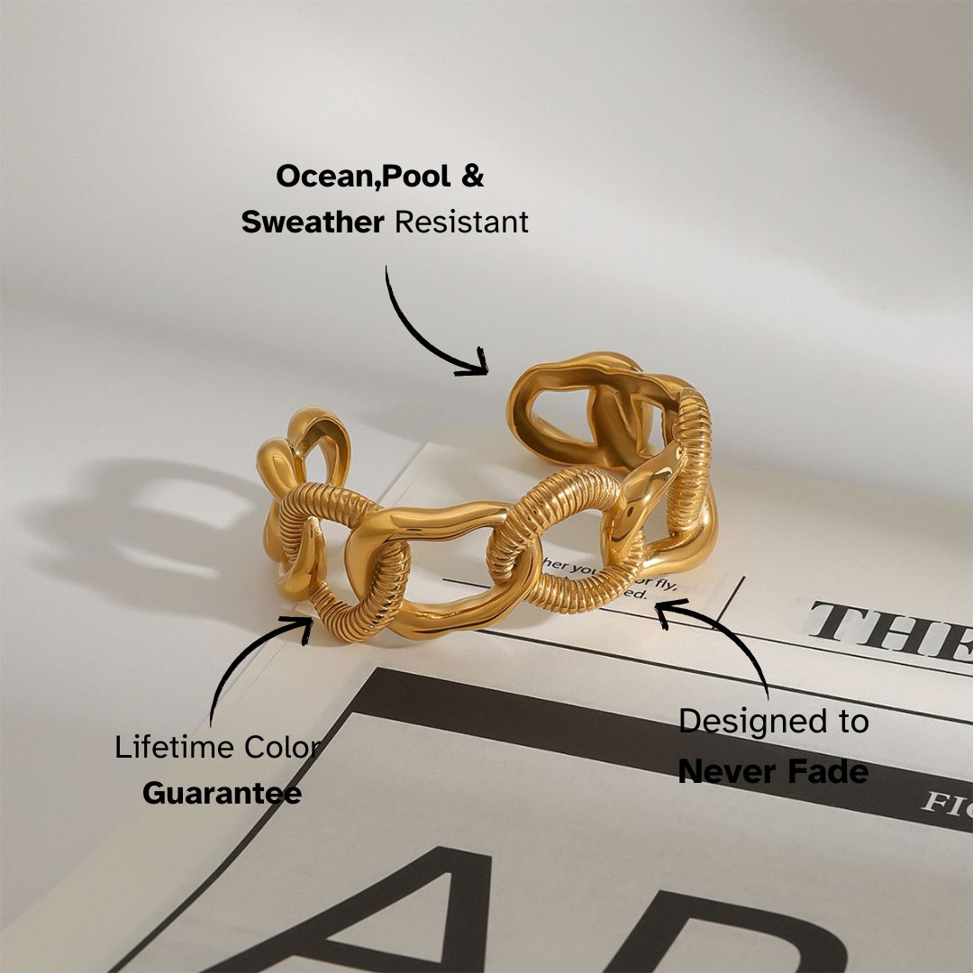 Chunky gold open cuff bracelet with textured links placed on a magazine — statement piece for chic daily outfits