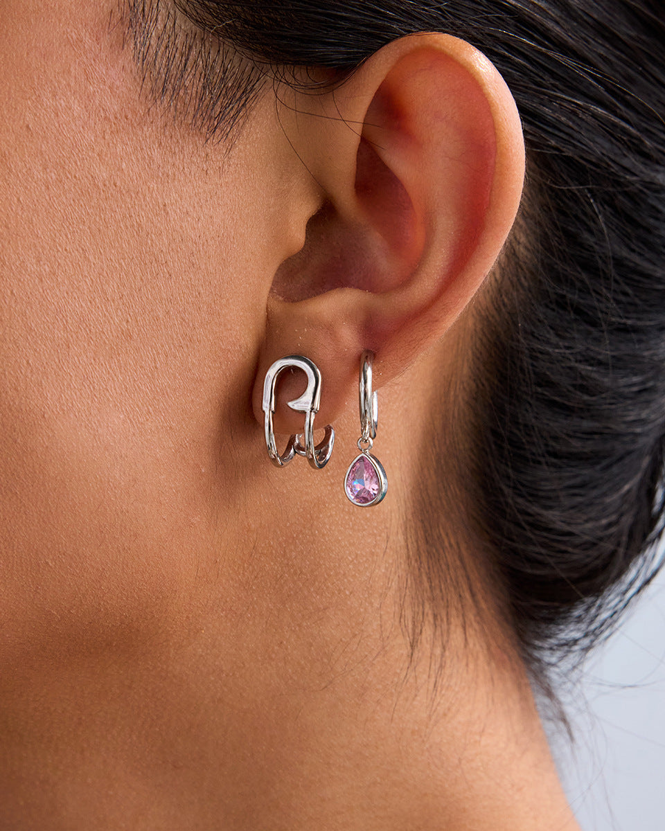 Side profile of woman wearing sleek silver hoops paired with pink gem drop earring