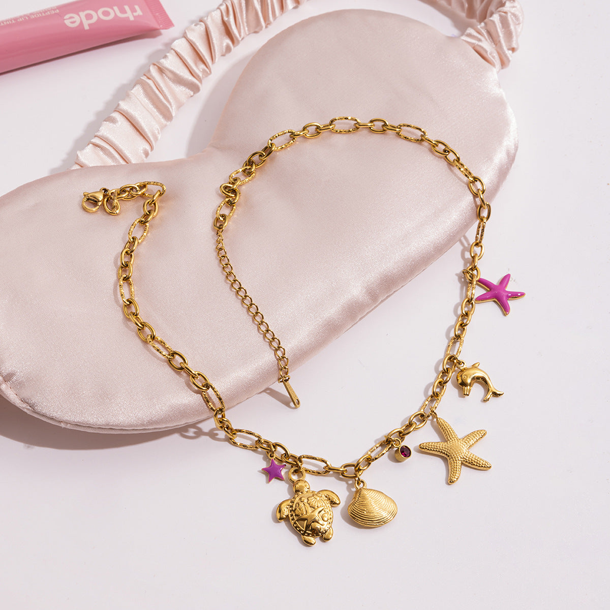 Gold chain necklace with shell, starfish, and pink accents