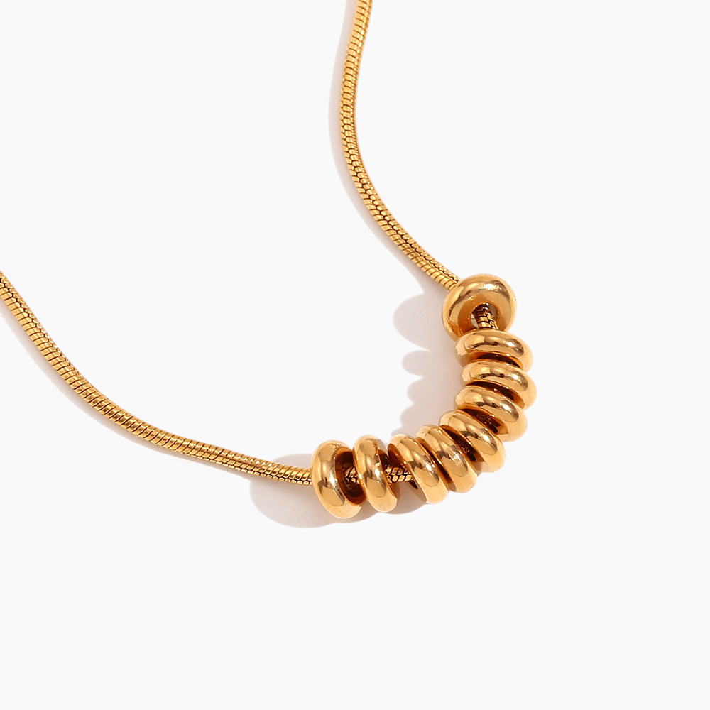 Gold necklace with a unique spiral design on a white background