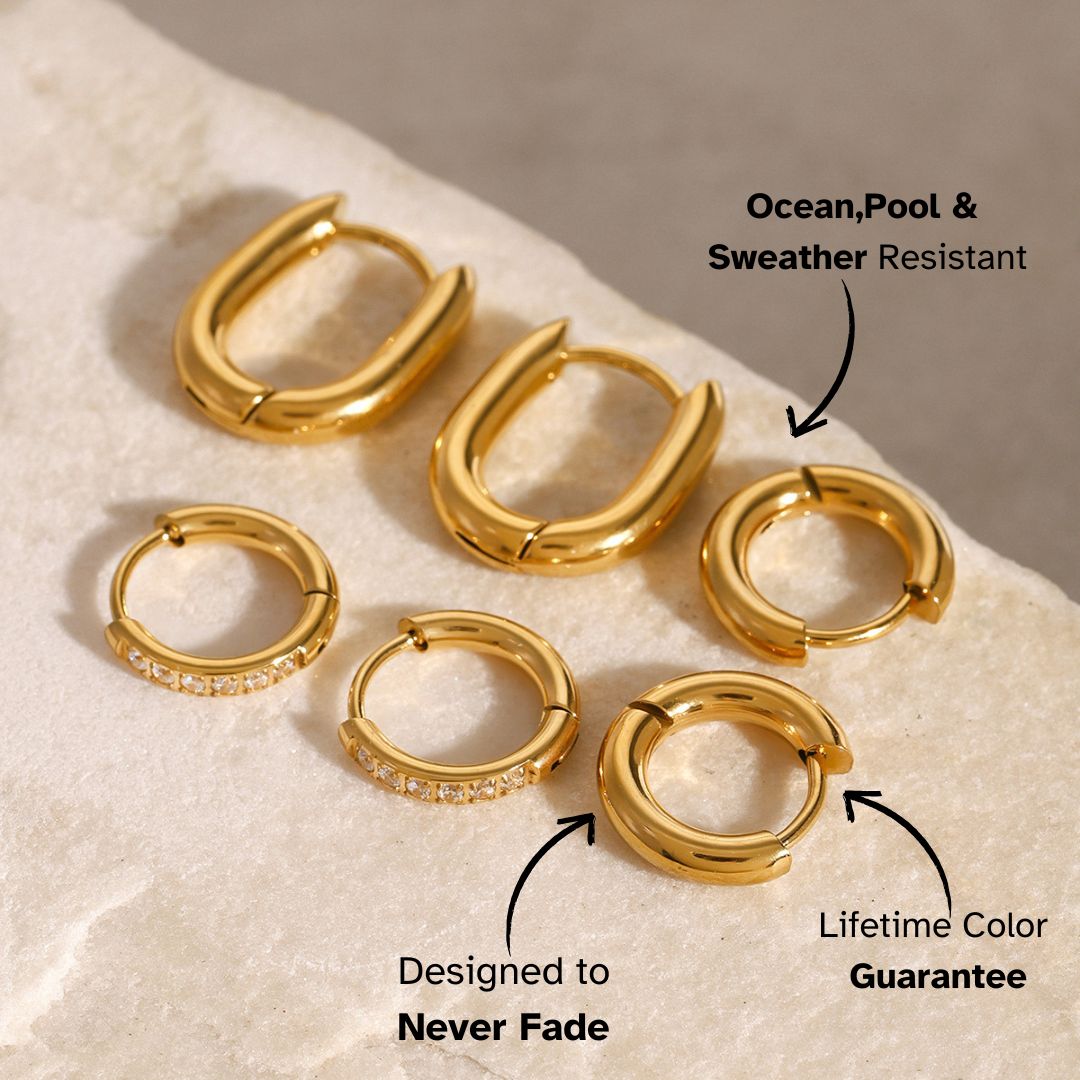 Small smooth gold round hoops on beige stone background