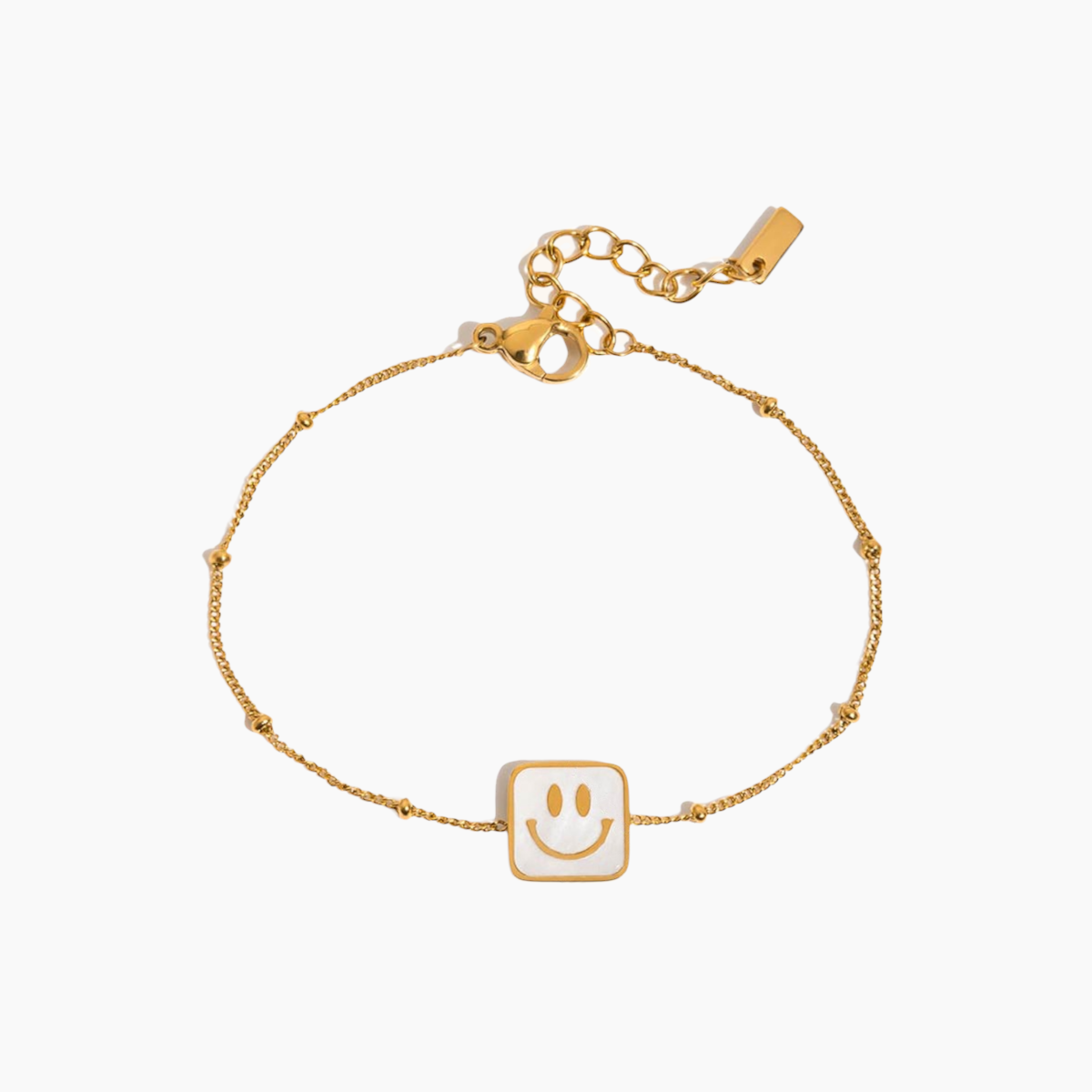 Gold bracelet with a smiley face charm on a white background