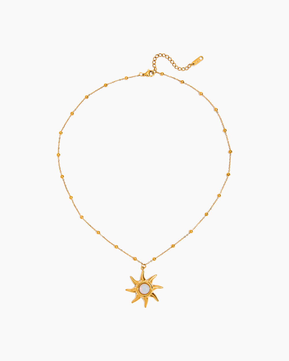Gold necklace with a sun-shaped pendant on a white background