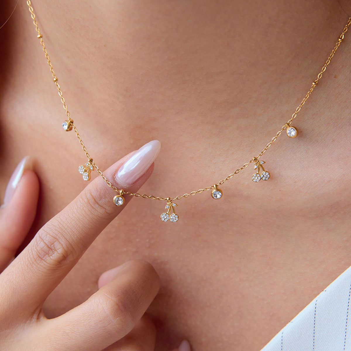 Close-up of gold cherry charm necklace worn on neck, perfect for summer accessorizing