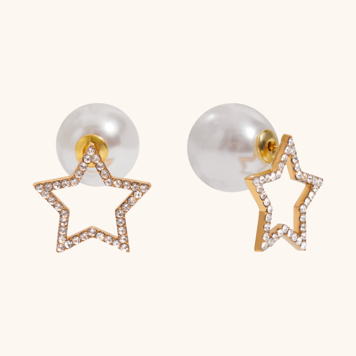 Gold open star earrings paired with pearl backs on cream background