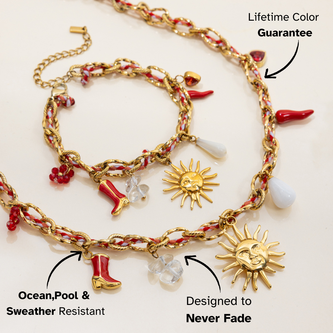 Gold and red charm bracelet with sun and boot charms on a white background
