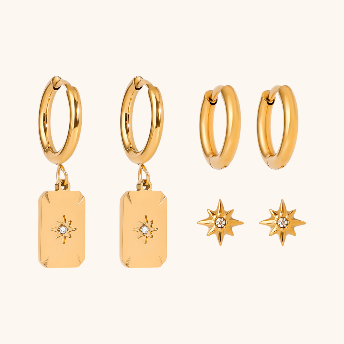Gold star charm earrings set with shiny hoop and starburst studs on white background