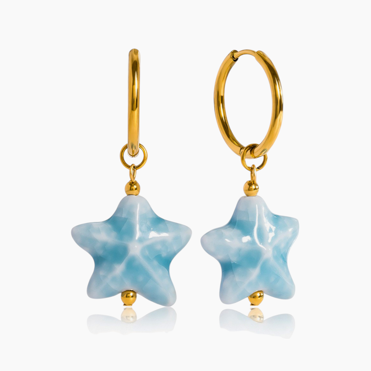 Gold hoop earrings with star-shaped blue stones on a white background