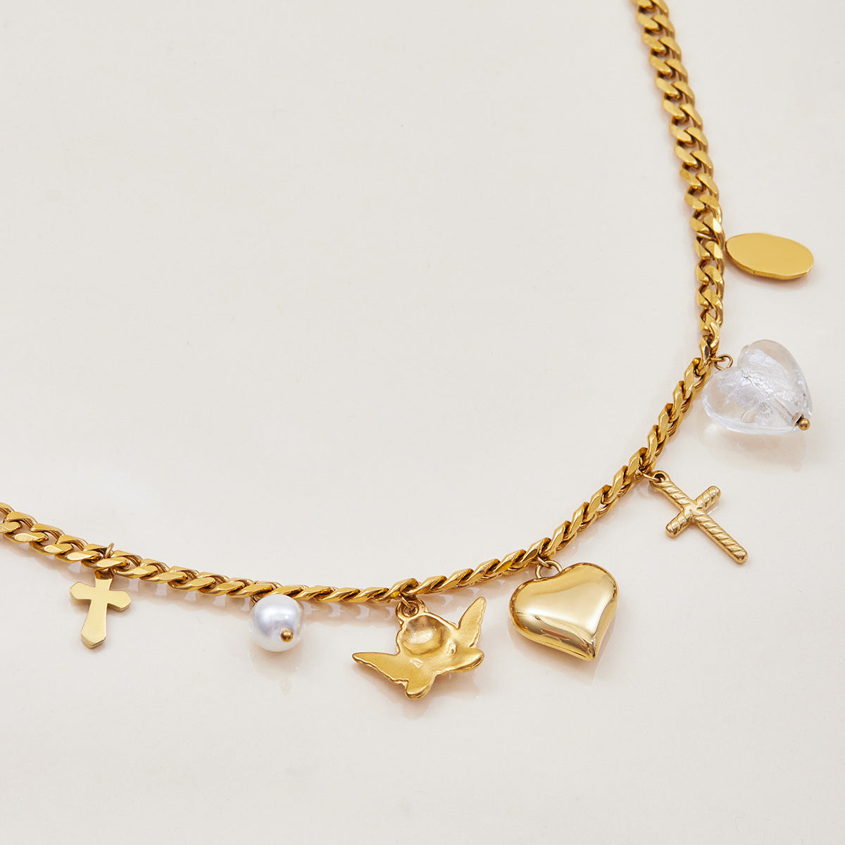 Detail shot of charm bracelet with glossy gold heart pendant