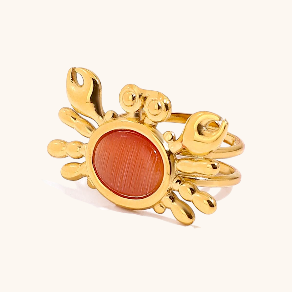 Product shot of adjustable crab ring with orange cat eye stone