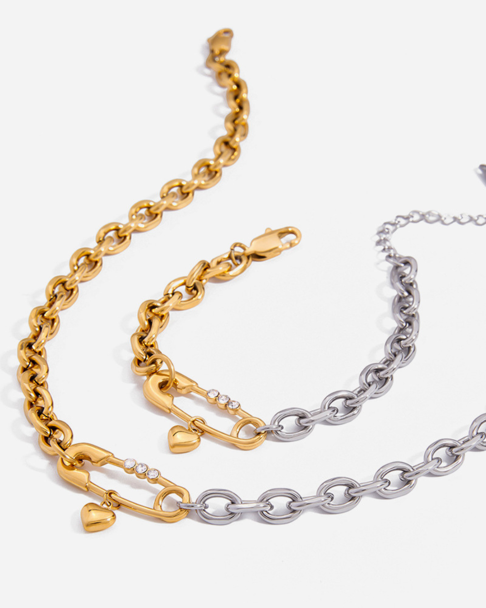 Two gold and silver chain bracelets on a white background
