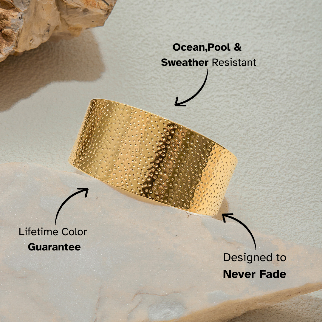 Gold bracelet on a textured surface with text highlighting features