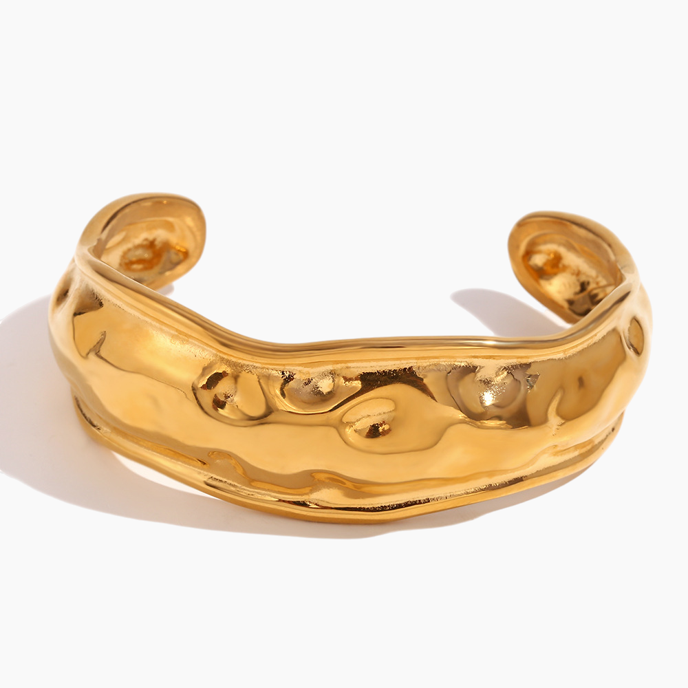 Wide hammered cuff styled alongside delicate bangles for layered effect