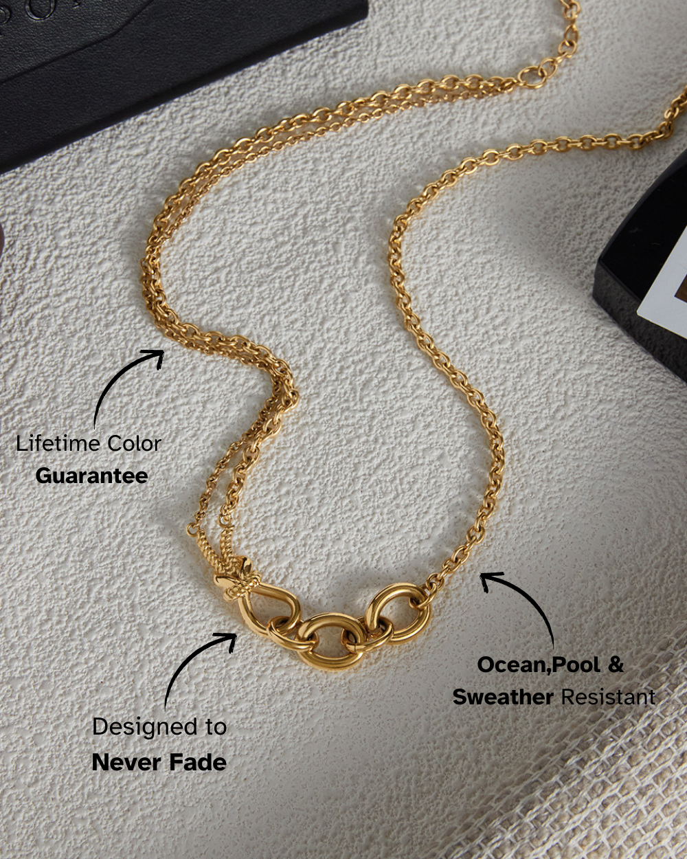 Gold chain necklace on a textured surface with text highlighting features.