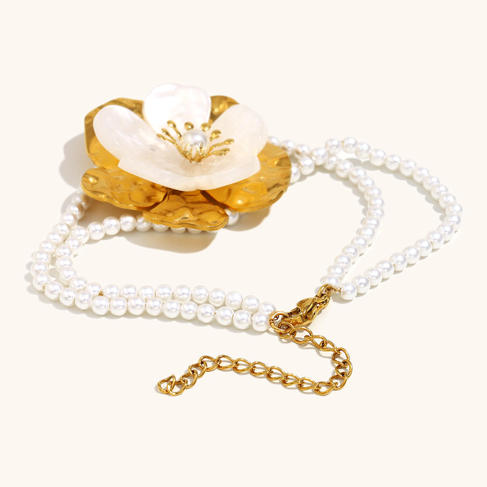 Close-up of flower-shaped pearl bracelet with gold hammered texture