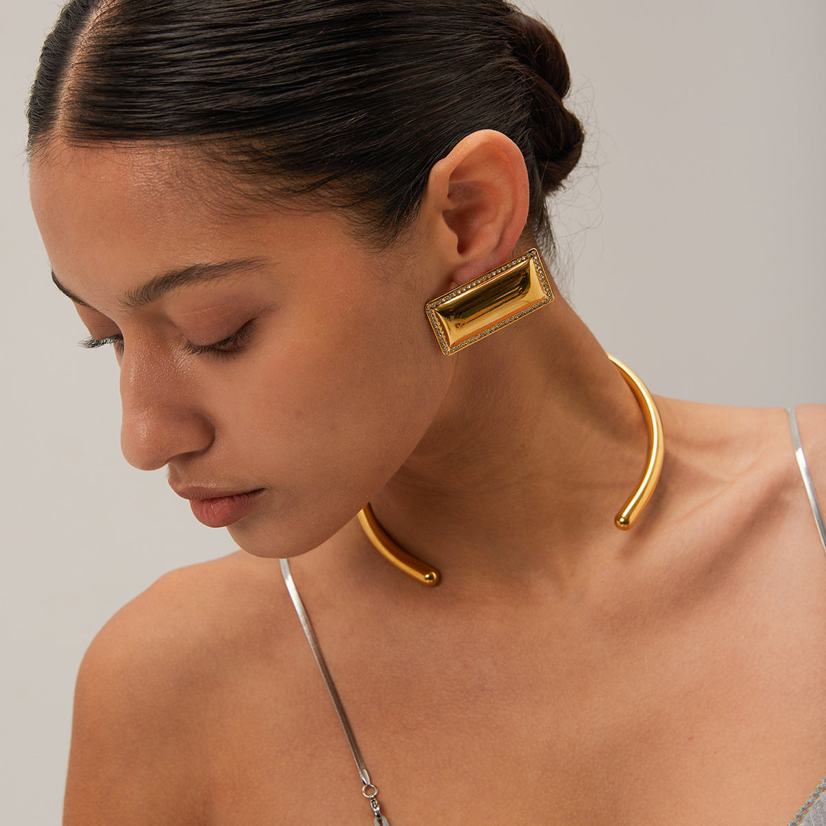 Woman wearing minimalist silver choker necklace with structured outfit