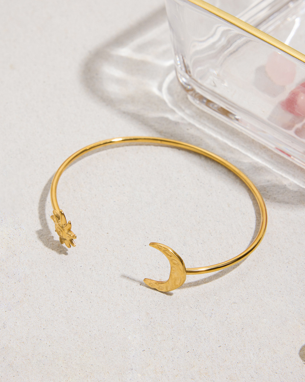 Gold bracelet with a moon design on a light background