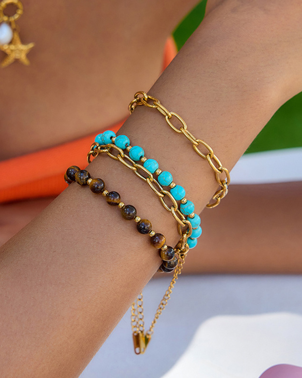 Close-up of a wrist wearing multiple bracelets with a blurred background