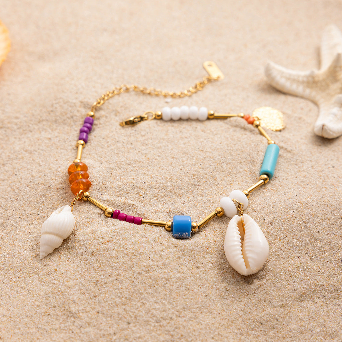 Colorful beaded necklace with shell pendants on a sandy background