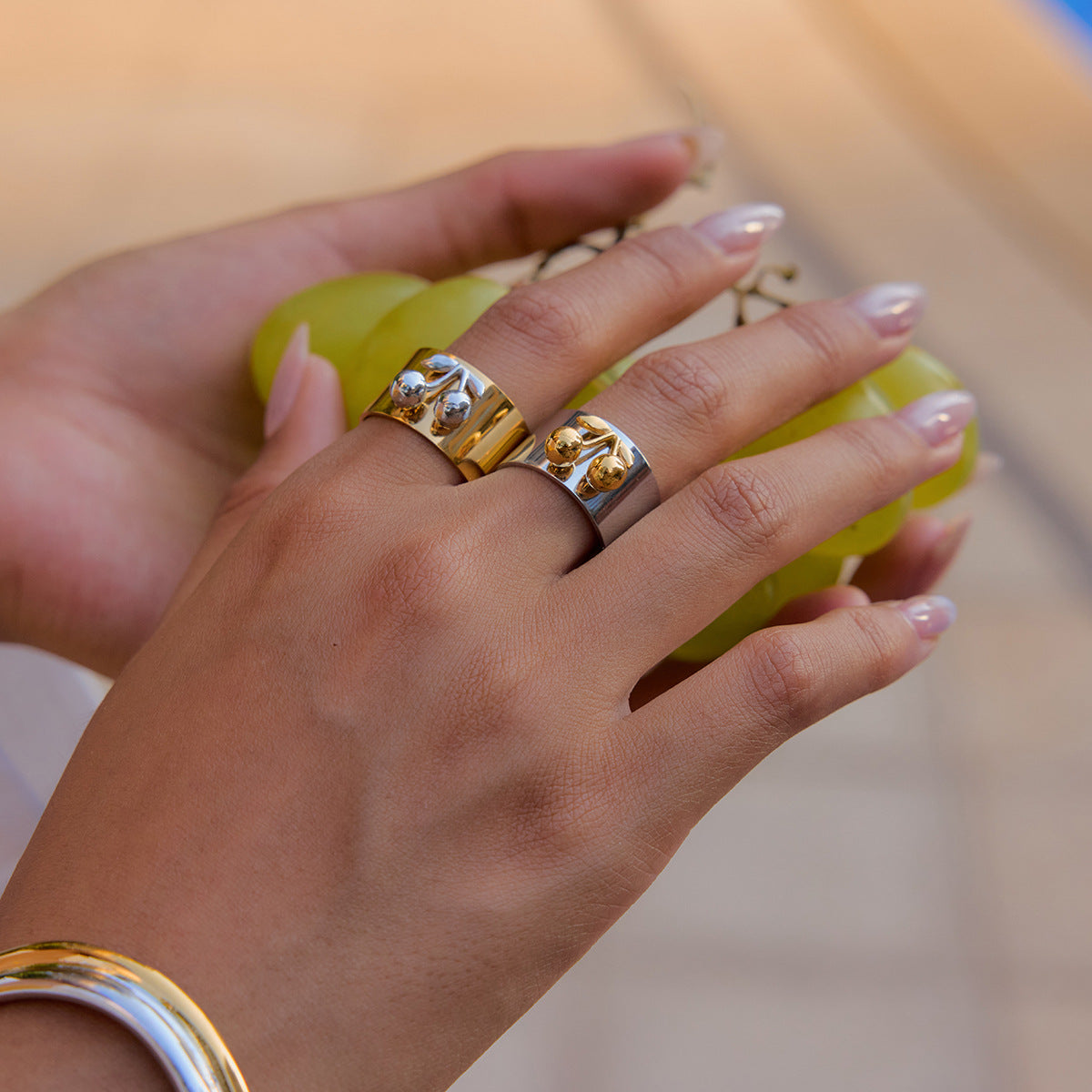 Close-up of silver band cherry ring on model's finger with grapes