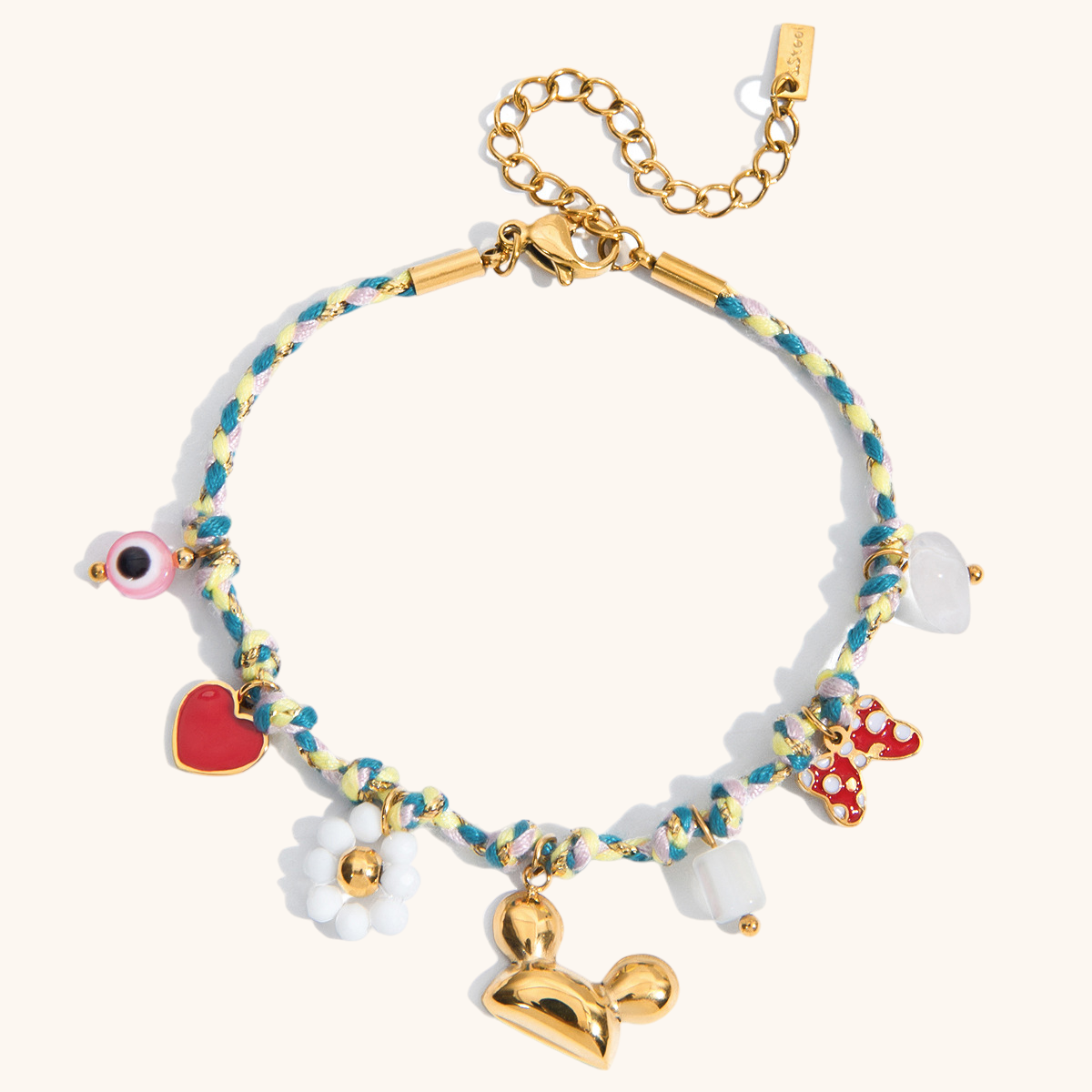 Flat lay of gold and enamel charm bracelet with pink and blue rope