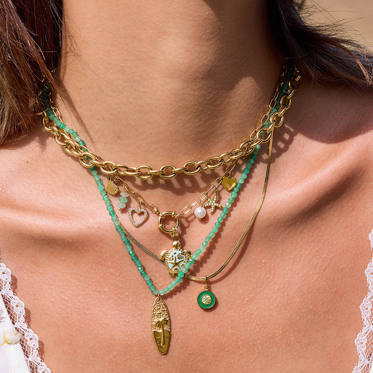 Ocean-resistant tropical charm necklace styled in layers