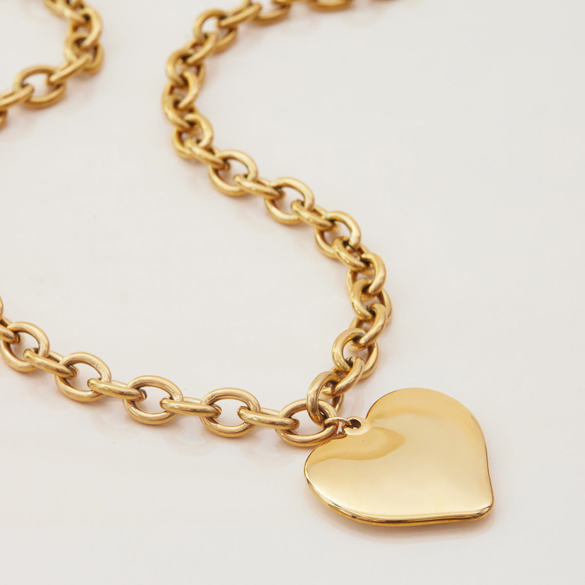 Necklace hanging vertically with heart-shaped sun pendant centered on chain