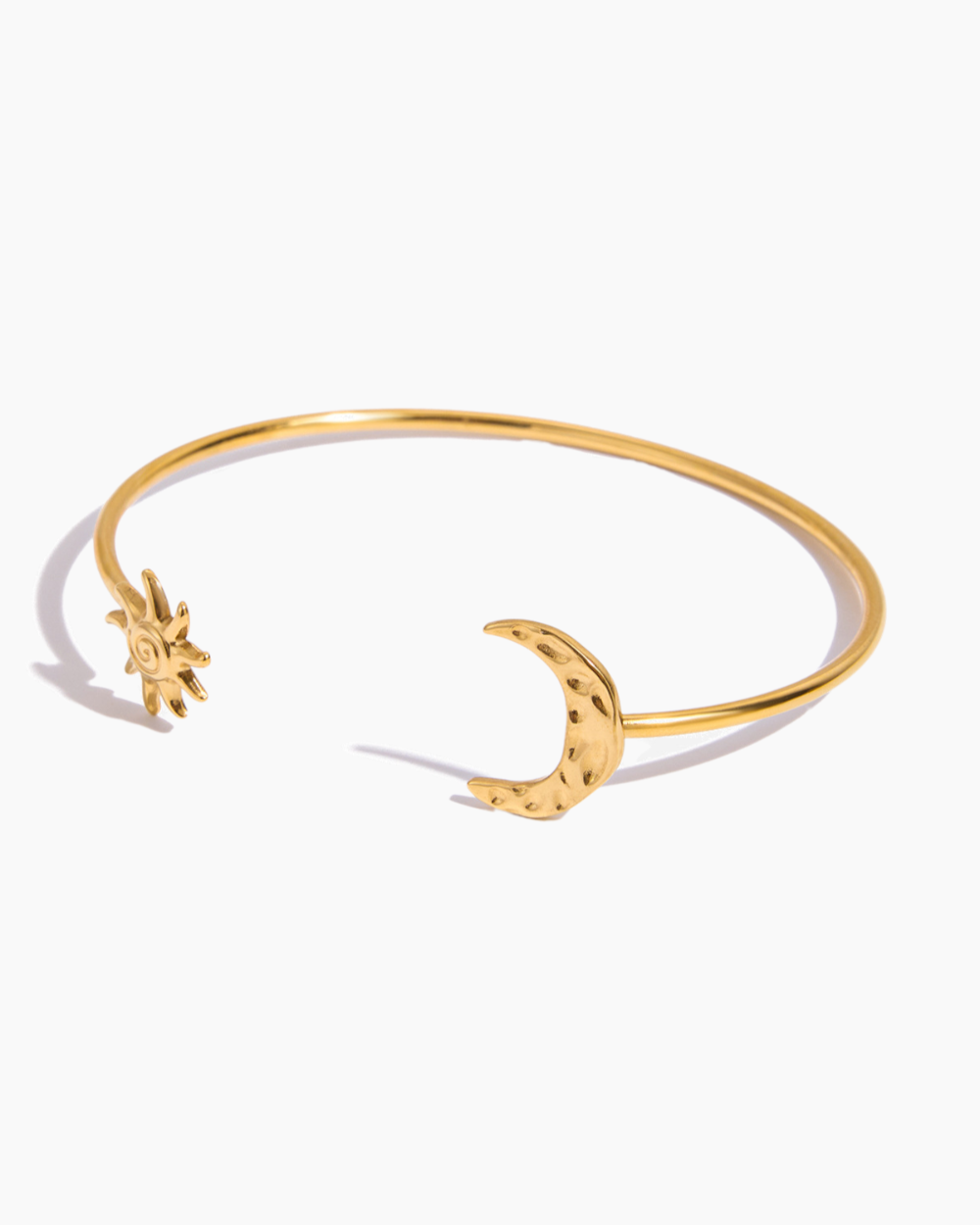 Gold bracelet with star and moon designs on a white background