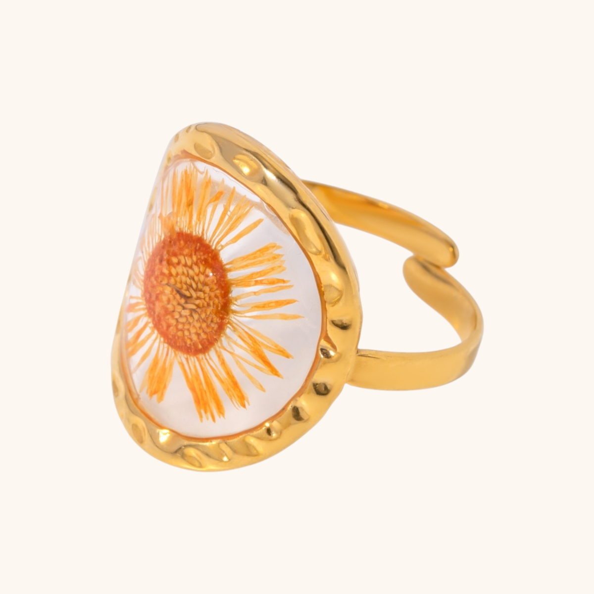 Close-up of gold daisy resin ring with bright orange petals and hammered frame