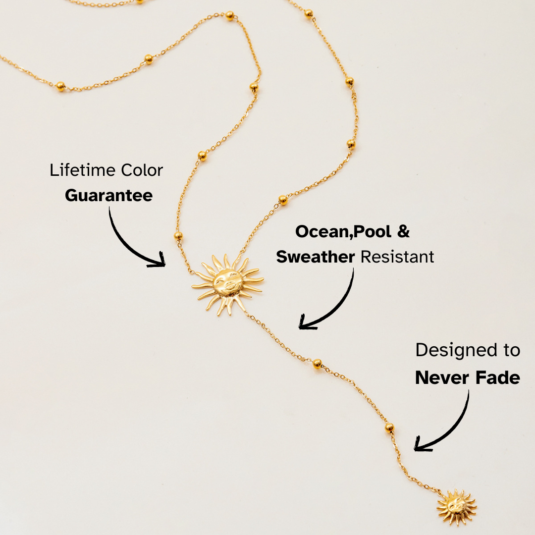 Gold necklace with sun designs on a light gray background, featuring text about its features.