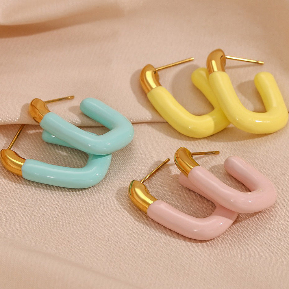 Bold yellow enamel U hoops with shiny gold tops, isolated on clean background