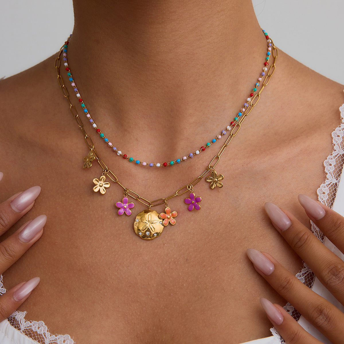 Model wearing colorful flower pendant necklace layered with gold chain, perfect for summer beach outfits.