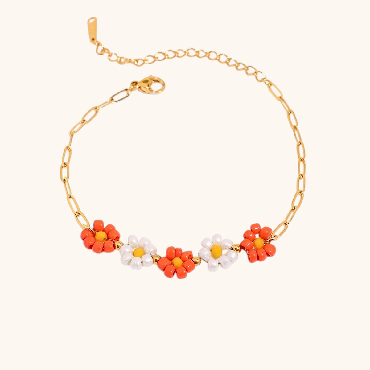 Orange and white daisy bracelet styled with gold chain on a soft surface