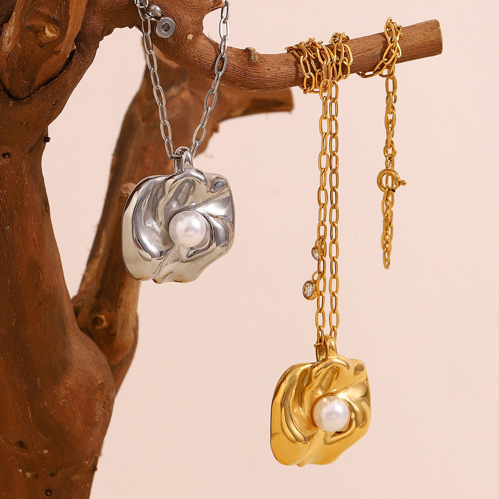 Close-up of sculpted gold floral pendant with centered pearl accent