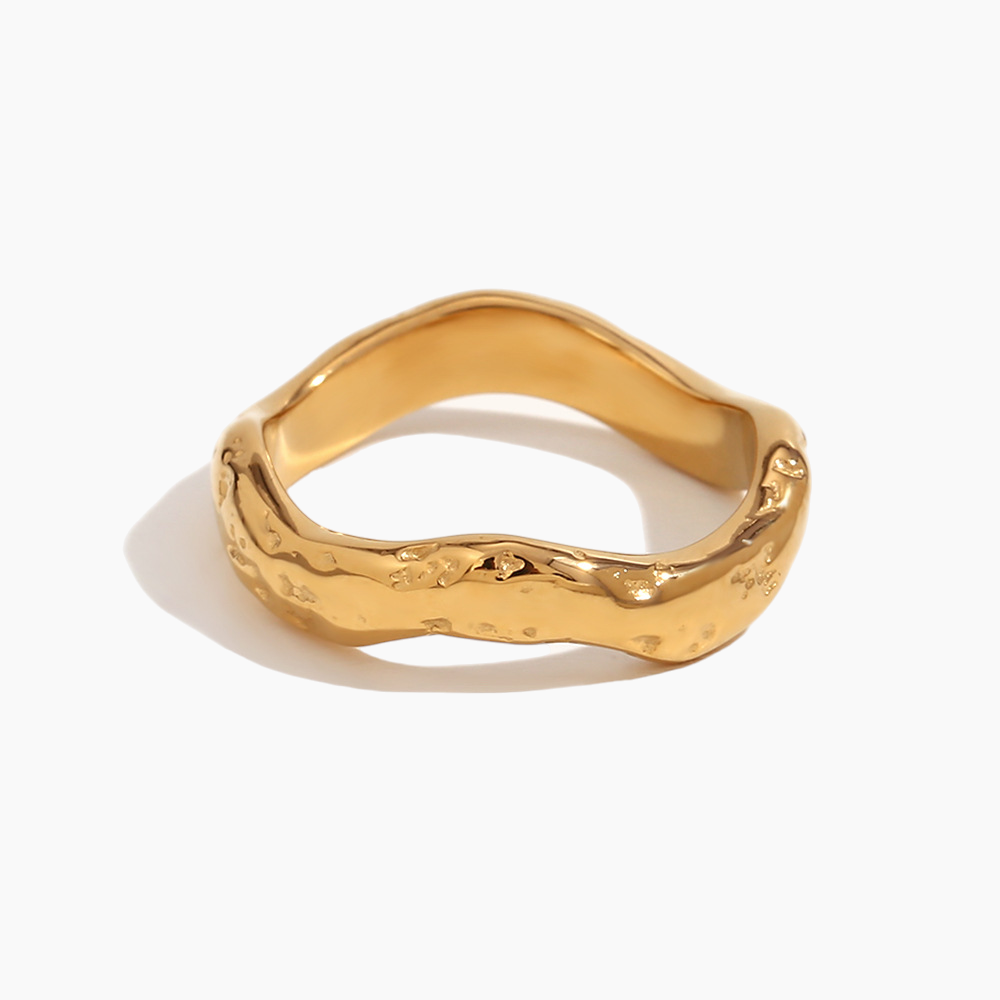 Gold ring with a wavy design on a white background